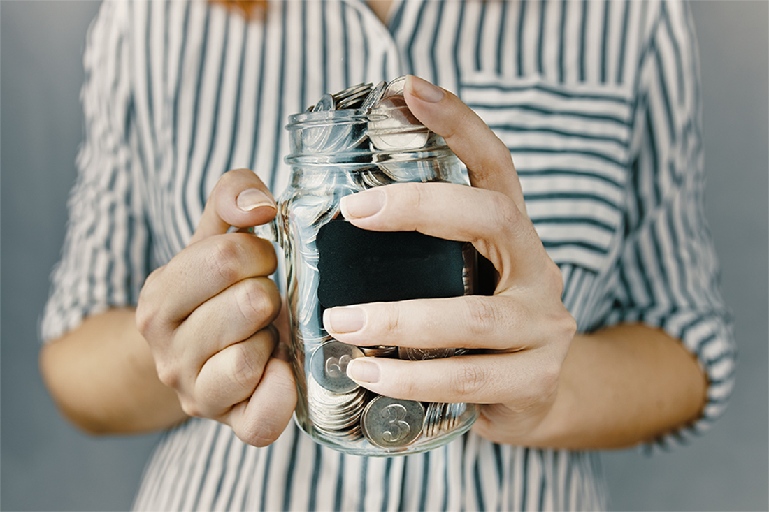 Image of a person holding a jar of coins